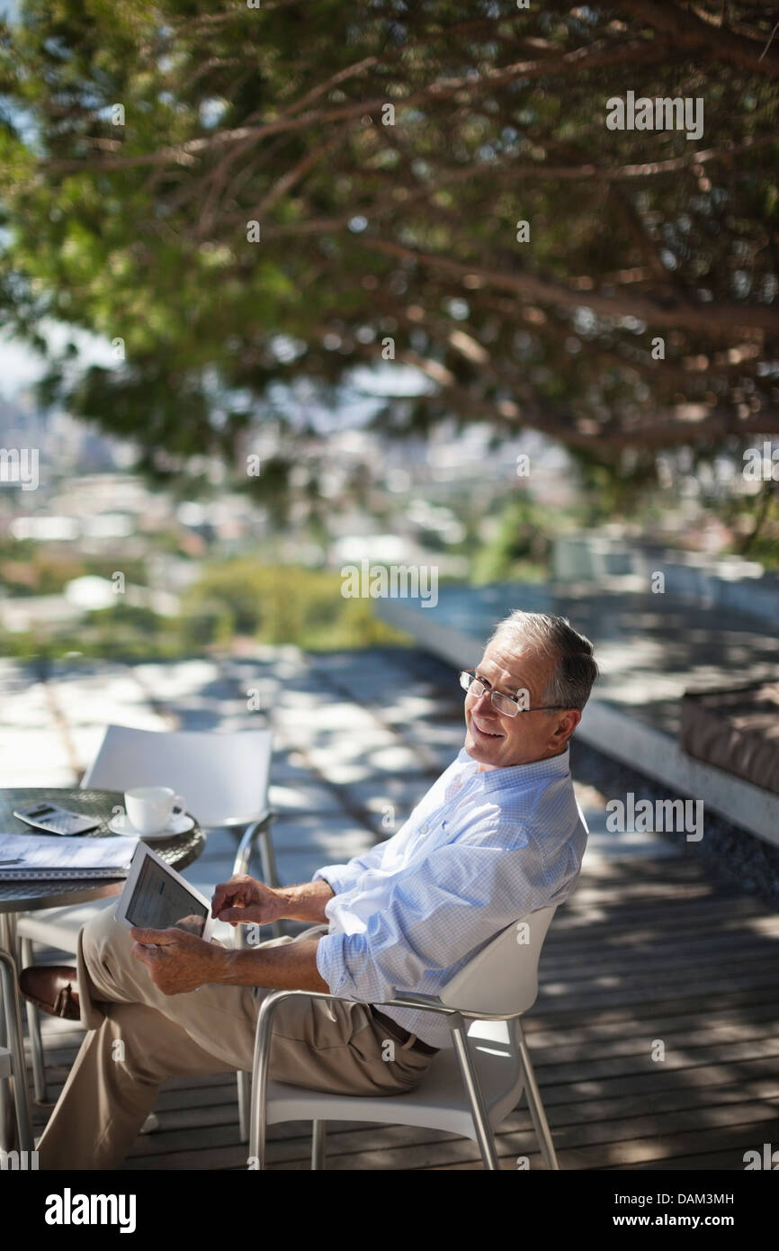Man using tablet computer outdoors Stock Photo
