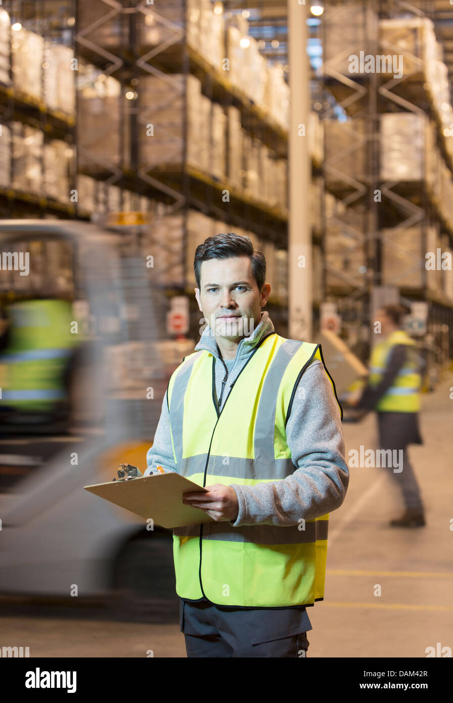 Worker writing on clipboard in warehouse Stock Photo