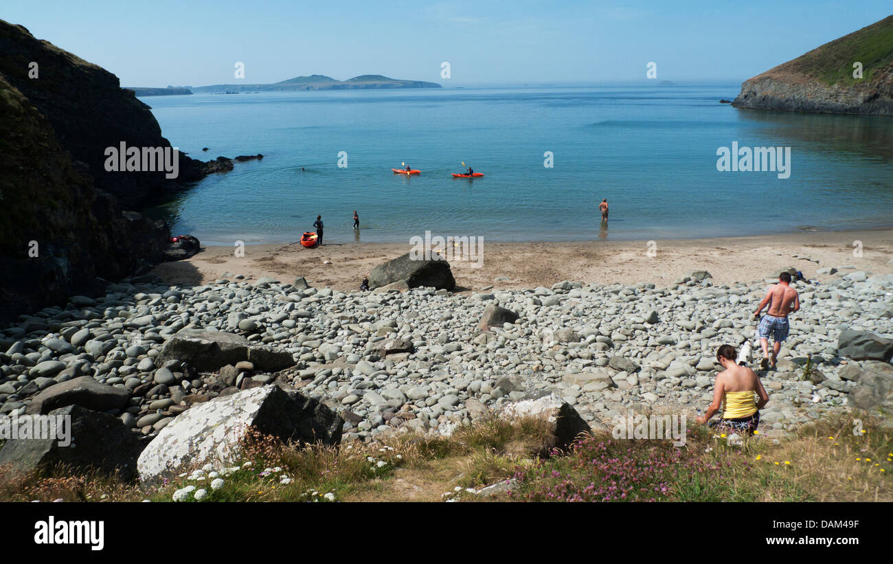 People with kayaks kayaking and walking on the beach at Porth Meigan near Whitesands Bay, St. David's Head, Pembrokeshire, Wales, UK Stock Photo