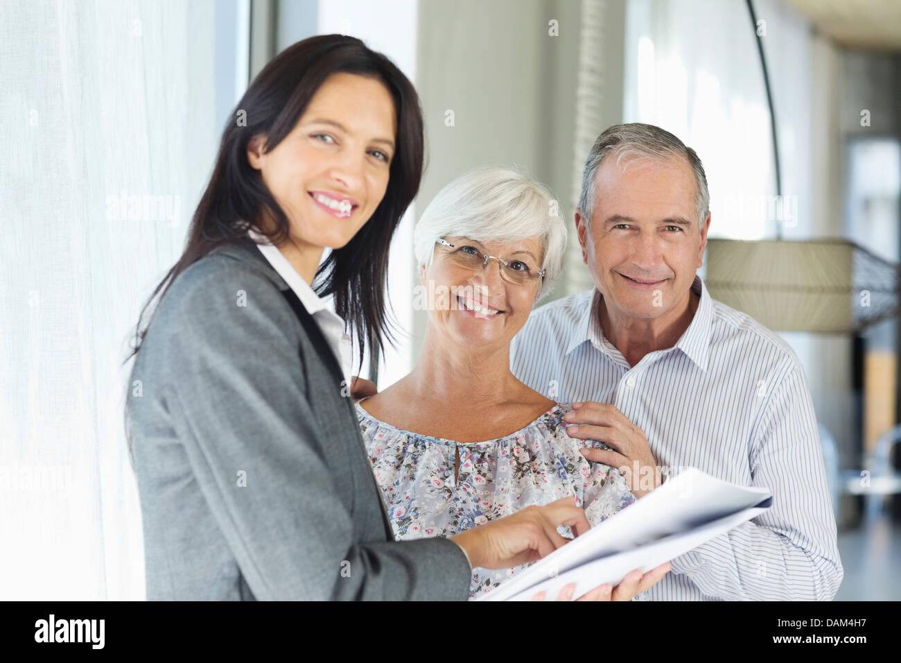 Financial advisor talking to couple indoors Stock Photo