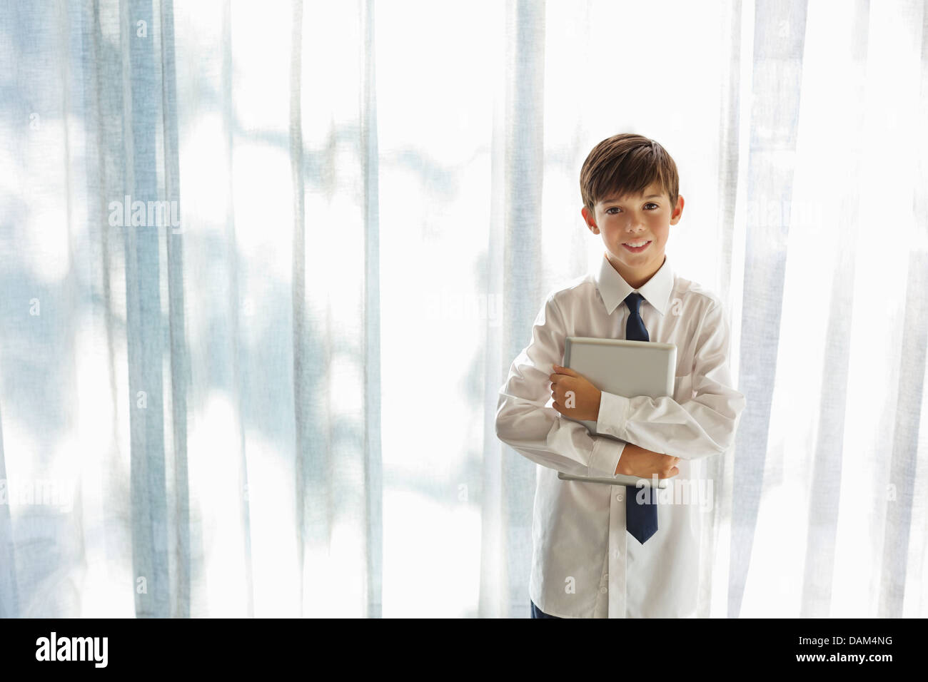 Boy in shirt and tie holding tablet computer Stock Photo