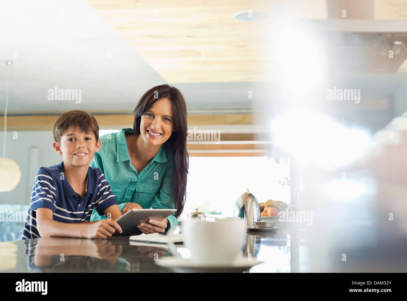 Mother and son using tablet computer in kitchen Stock Photo