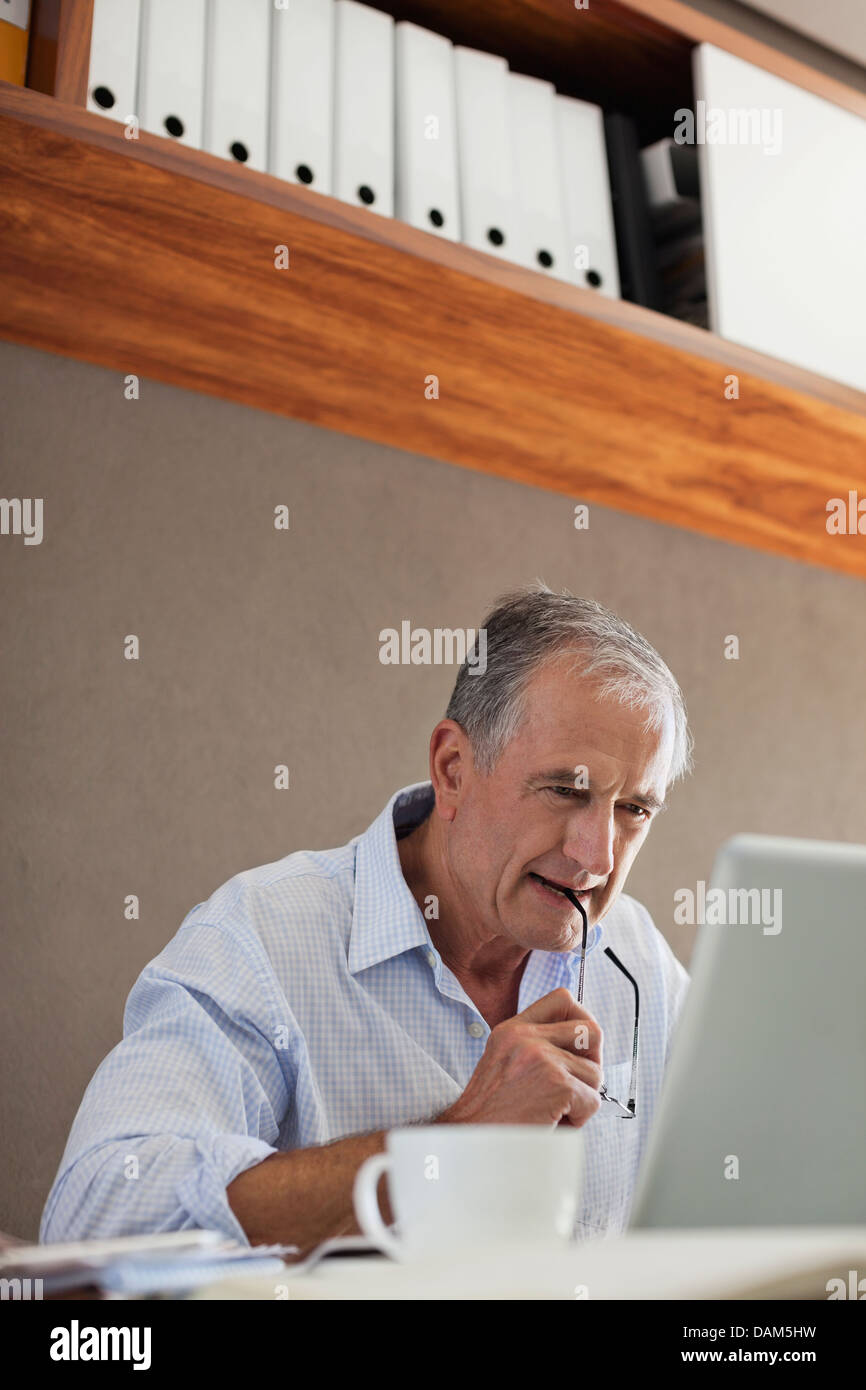 Older man working at desk Stock Photo