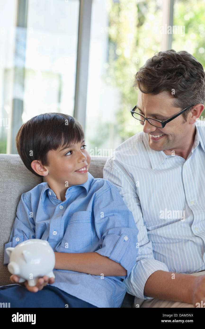 Father and son holding piggy bank Stock Photo - Alamy