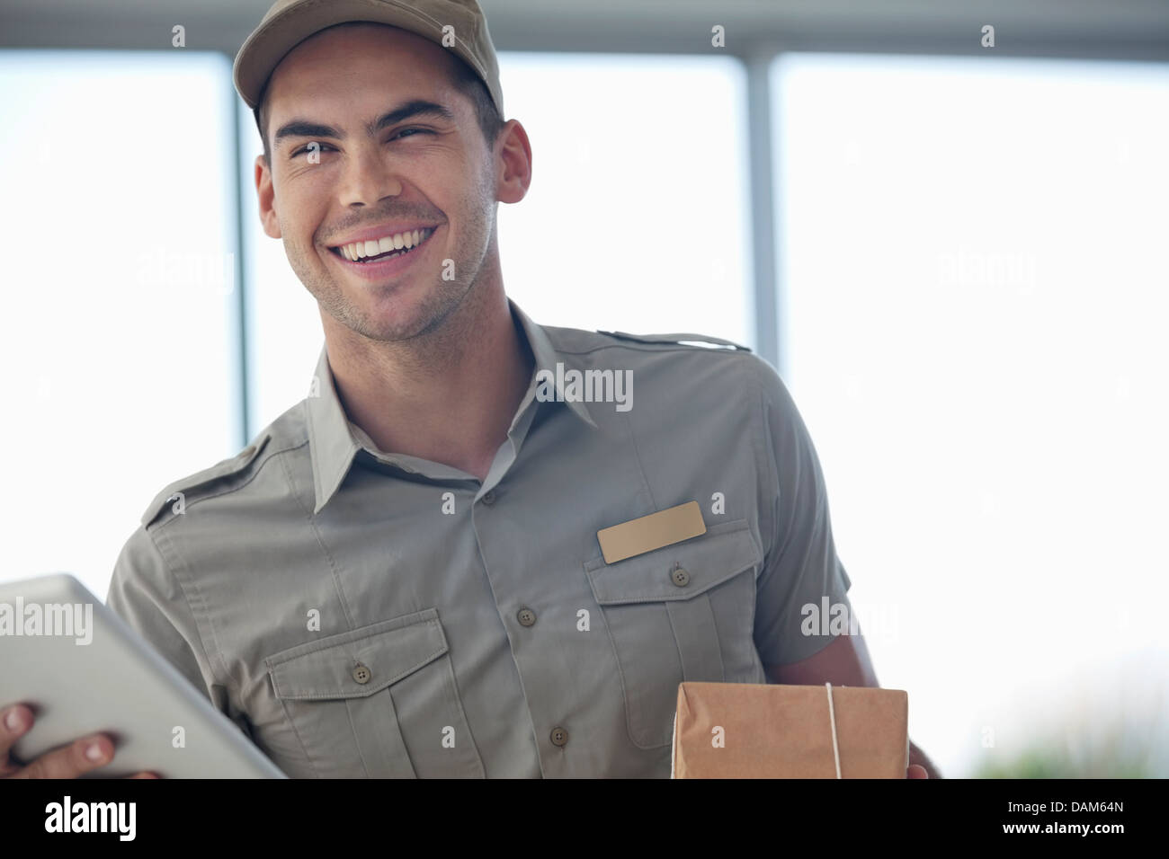 Delivery boy smiling with package Stock Photo