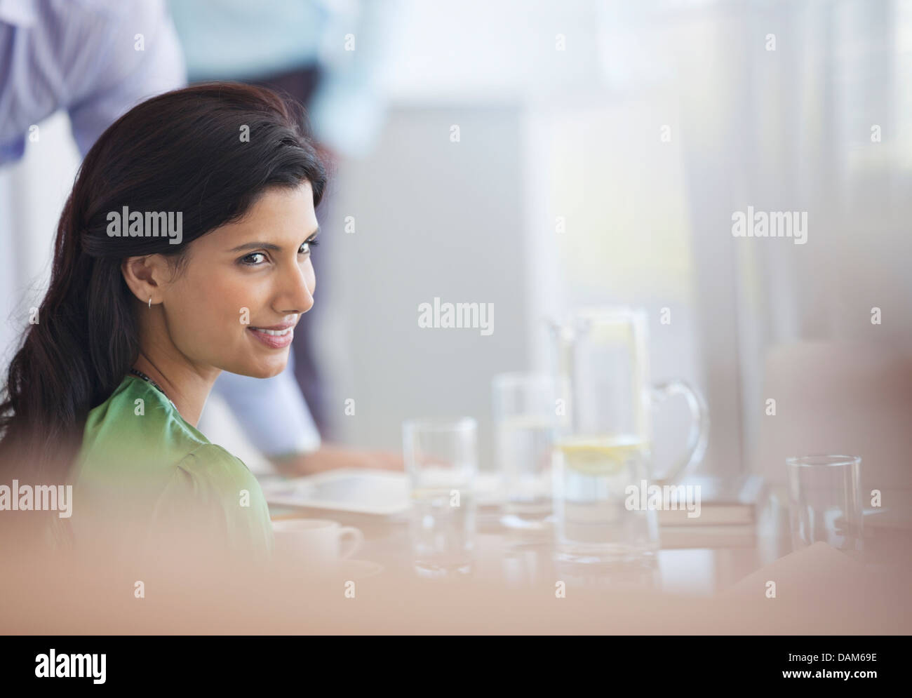 Businesswoman smiling at meeting table Stock Photo