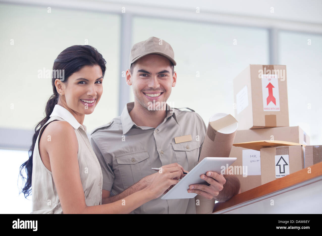 Woman signing for packages from delivery boy Stock Photo