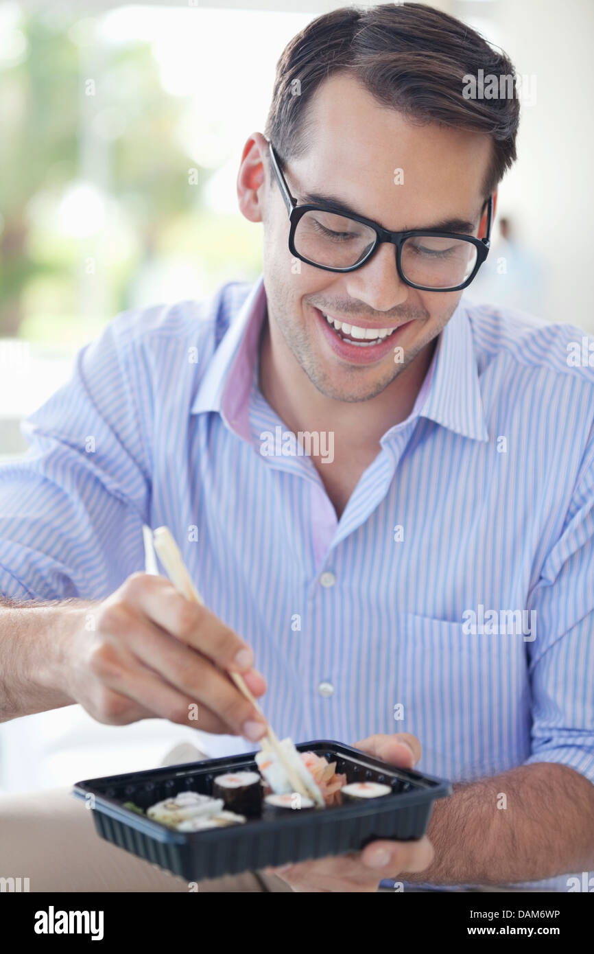Businessman eating sushi in office Stock Photo Alamy