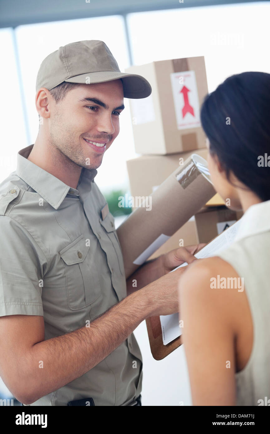 Delivery boy with packages for businesswoman Stock Photo