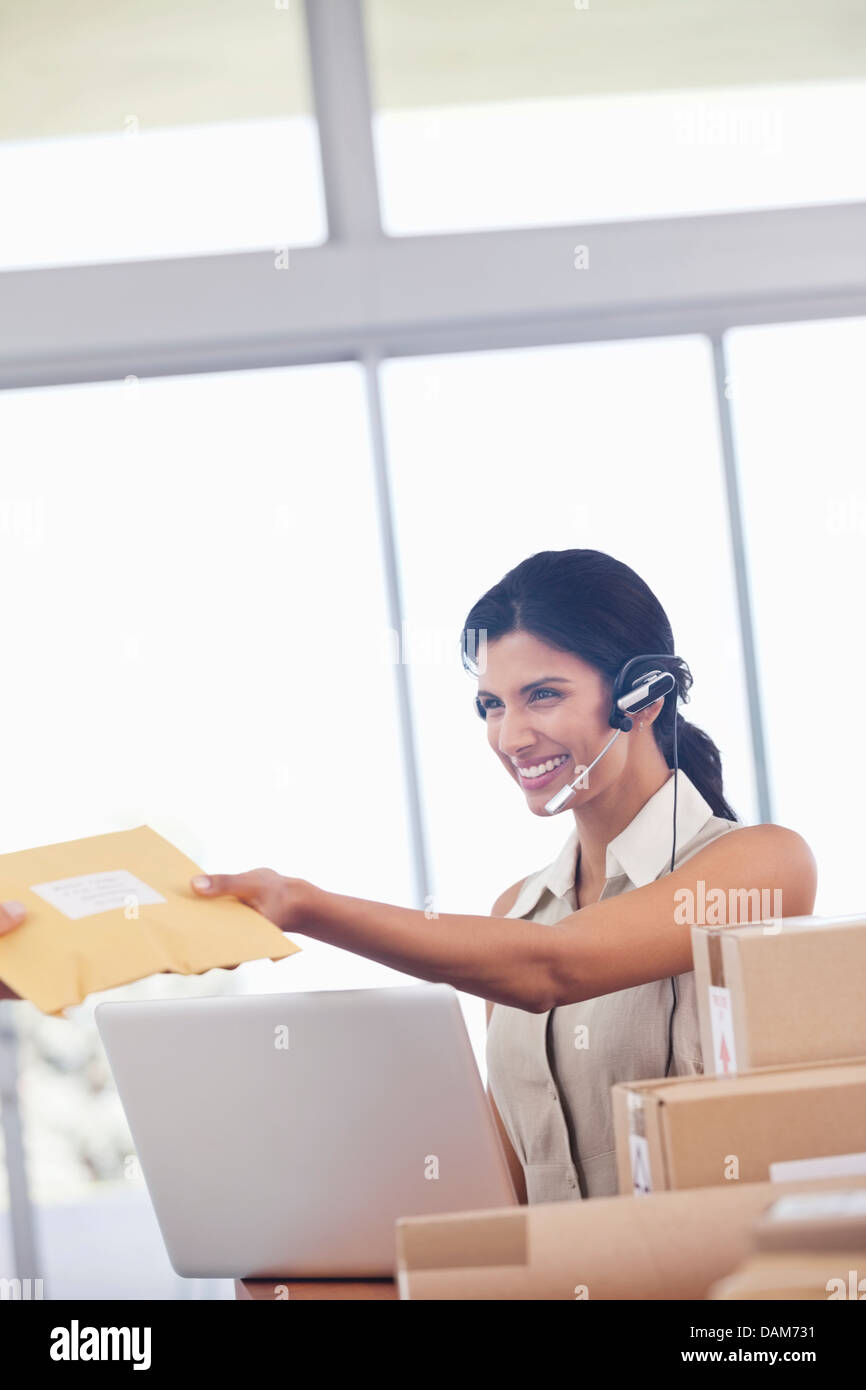 Businesswoman accepting packages in office Stock Photo