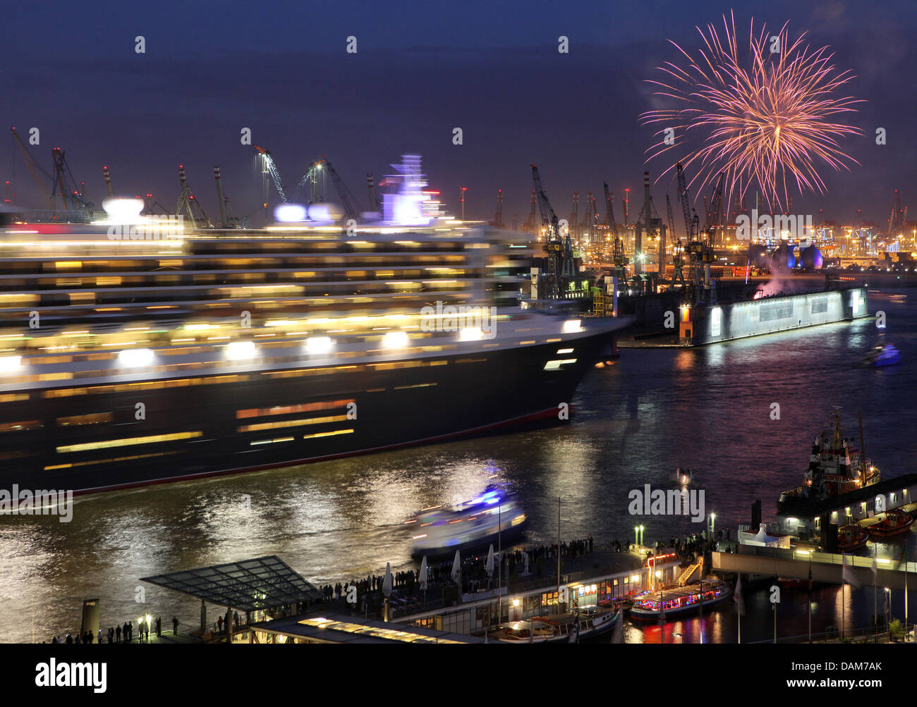 Cruise ship 'Queen Mary 2' leaves the port and is saluted with fireworks in Hamburg, Germany, 26 May 2011. The luxury cruise ship stayed in the Hamburg harbour for one day and afterwards left for Scandinavia. Photo: Bodo Marks Stock Photo