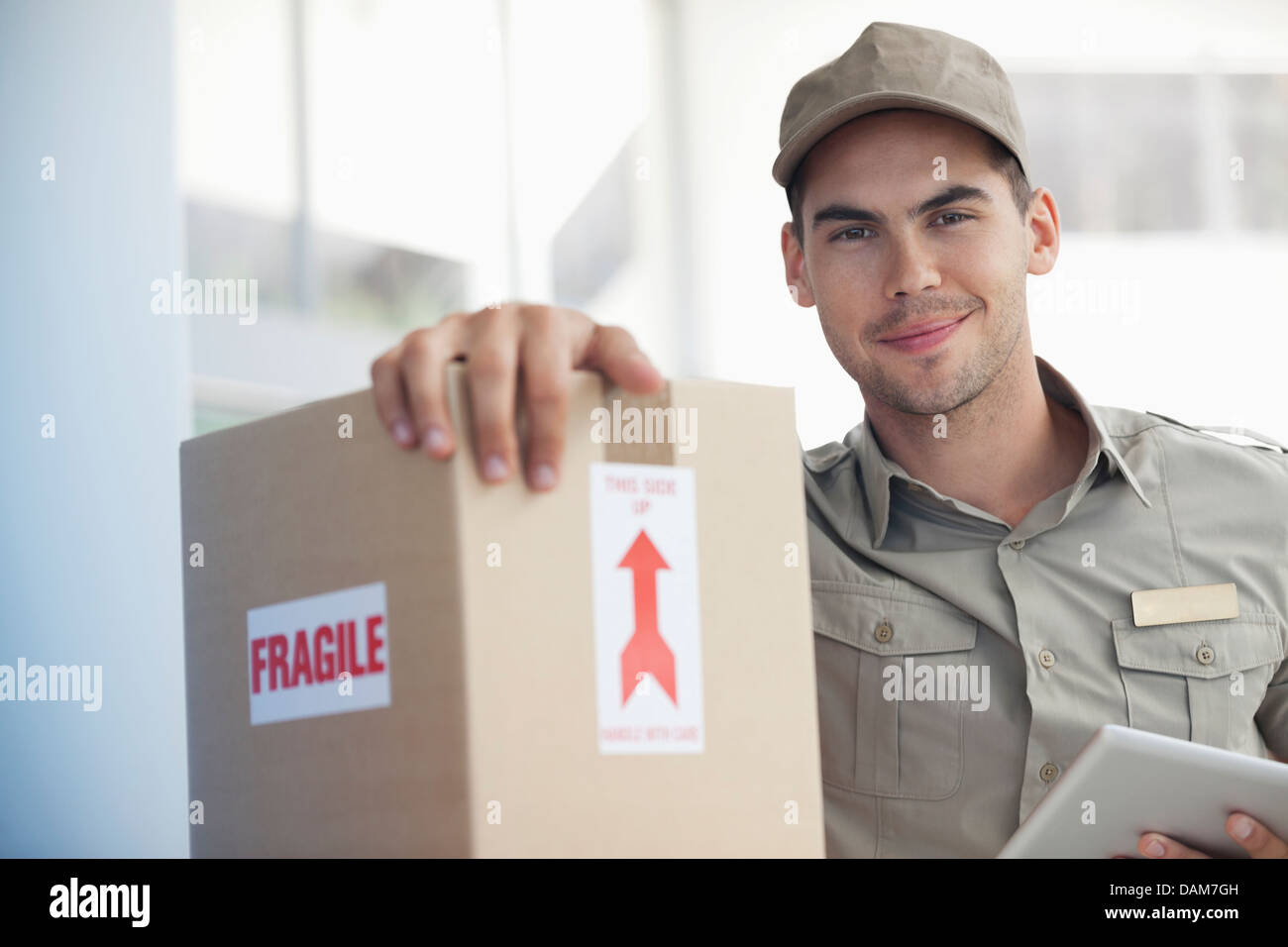 Delivery boy carrying ‘fragile’ package Stock Photo