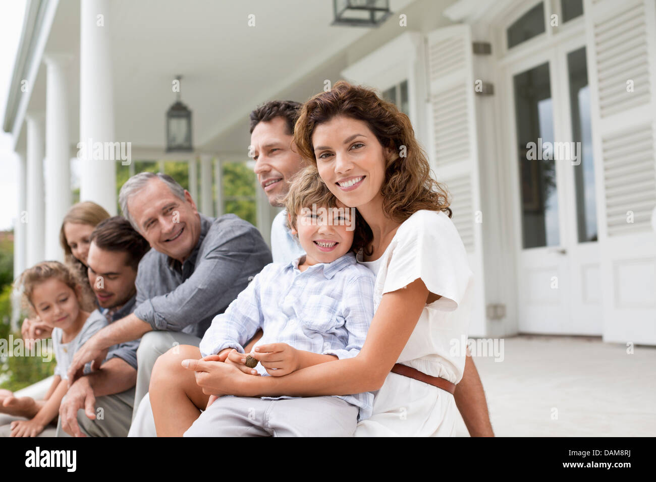 Family relaxing on porch together Stock Photo