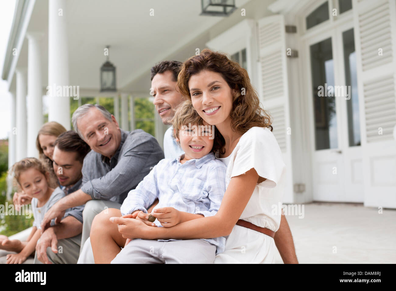 Family relaxing on porch together Stock Photo - Alamy