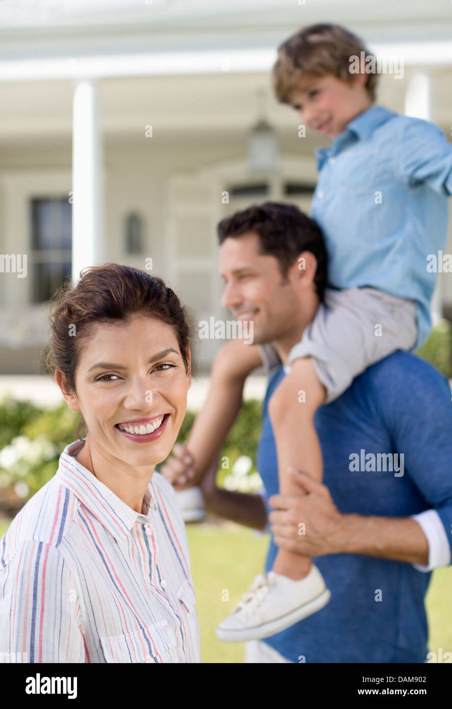 Family smiling outside house Stock Photo - Alamy