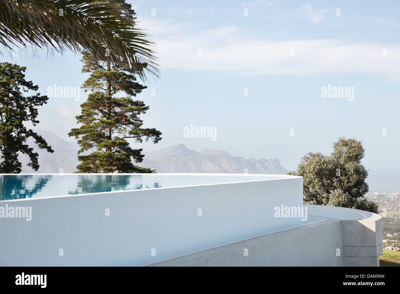 Infinity pool overlooking trees and hillside Stock Photo