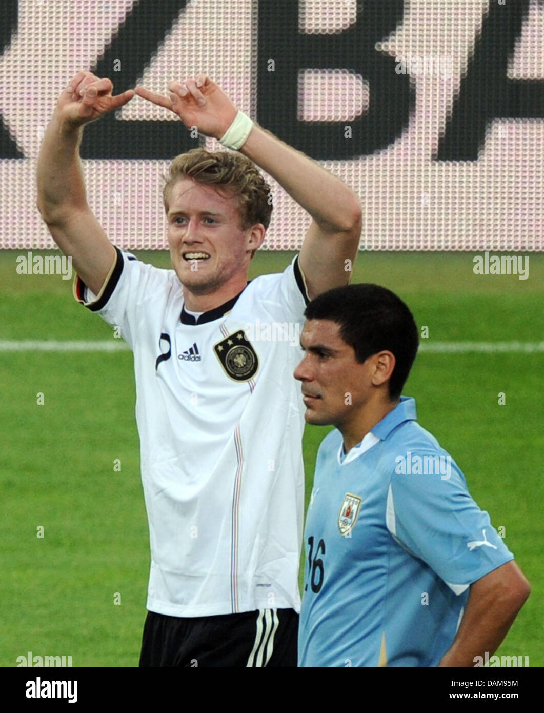 Germany's Andre Schuerrle celebrates after scoring the 2-0 next to Maxi Pereira of Uruguay during the soccer friendly Germany vs. Uruguay at Rhein-Neckar-Arena in Sinsheim, Germany, 29 May 2011. Germany won the friendly match 2-1. Photo: Uli Deck Stock Photo