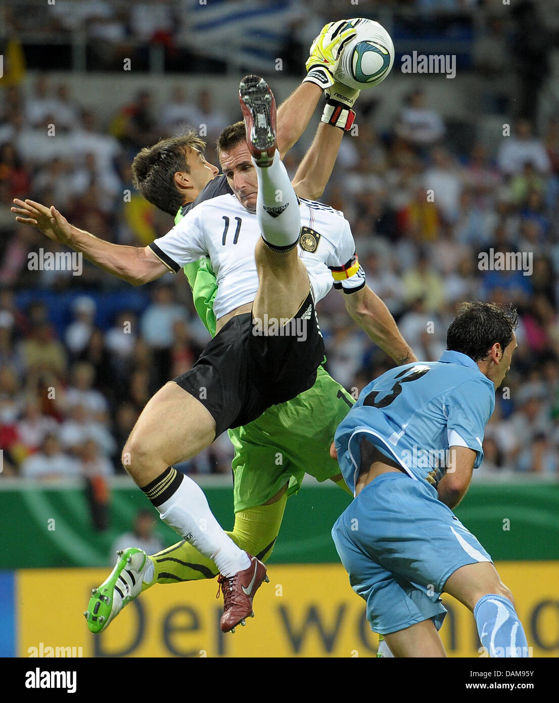 Germany's Miroslav Klose (front) and Goalkeeper Fernando Muslera of Uruguay  vie for the ball during the soccer friendly Germany vs. Uruguay at  Rhein-Neckar-Arena in Sinsheim, Germany, 29 May 2011. Germany won the