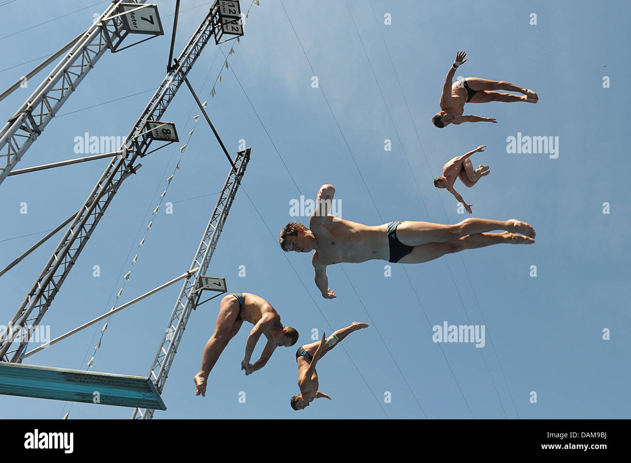 Five highdivers jump from their podium into the water during the