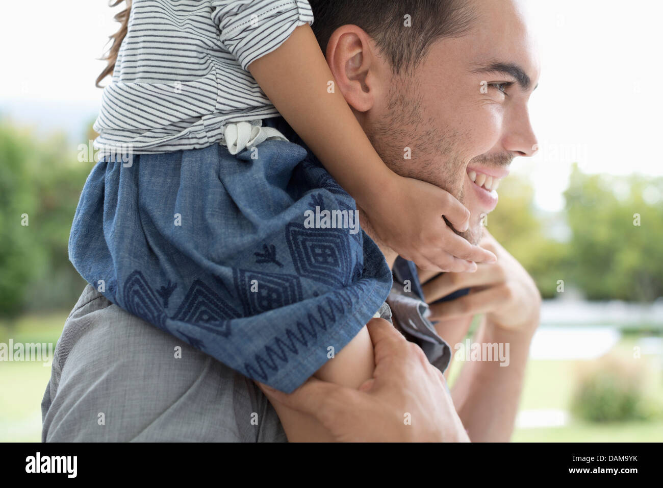 Father carrying daughter on shoulders outdoors Stock Photo