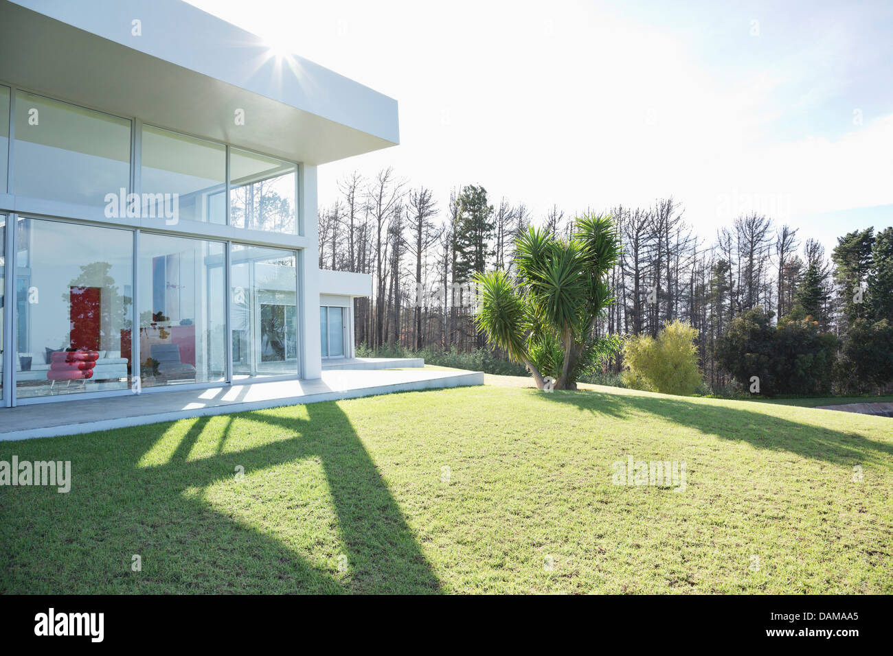 Modern house casting shadows on manicured lawn Stock Photo