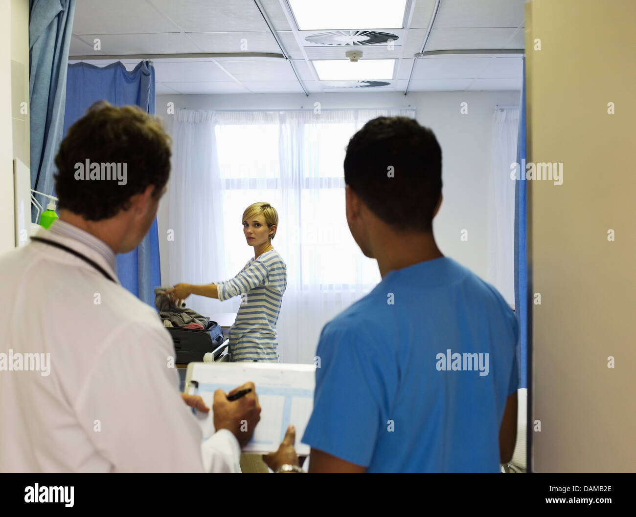 Doctor and nurse watching patient pack in hospital room Stock Photo