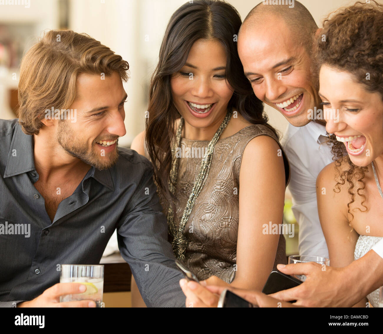 Friends using cell phones at party Stock Photo