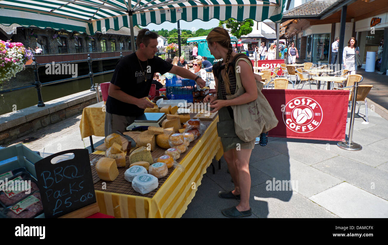 Woman buying Dutch cheese at Haverfordwest open air market stall in Haverfordwest Pembrokeshire Wales UK  KATHY DEWITT Stock Photo