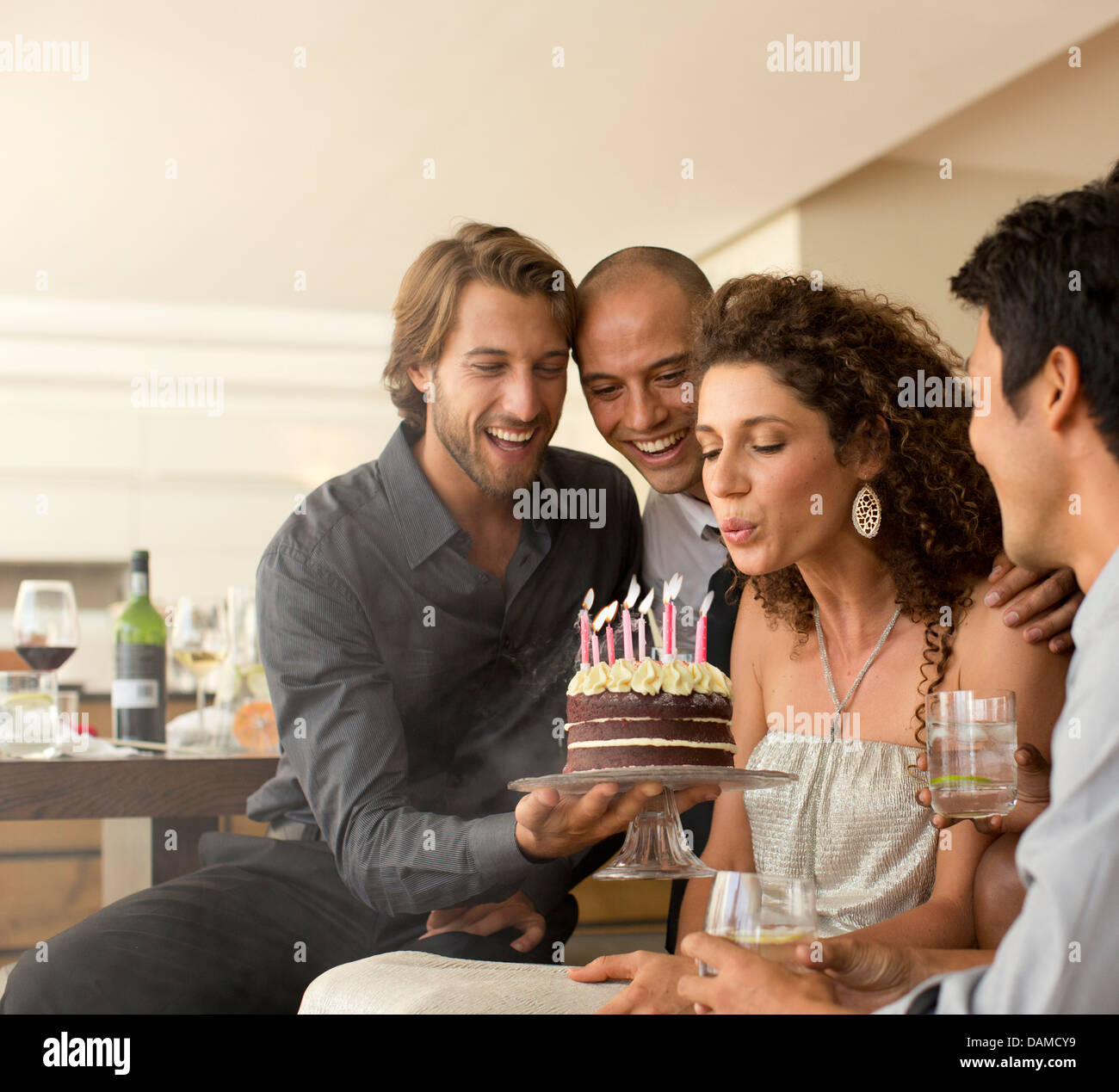 Woman blowing out birthday candles Stock Photo