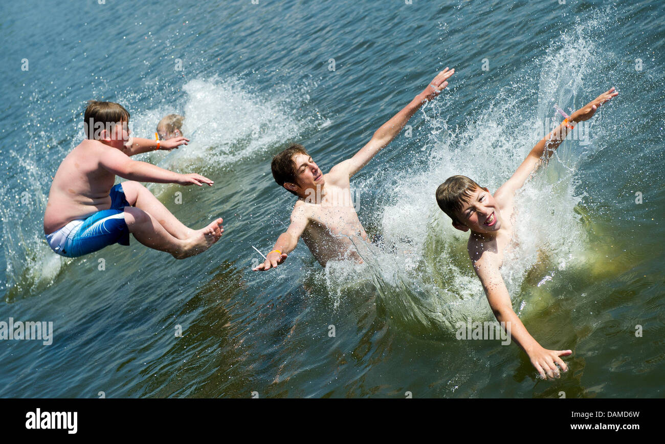 Four boys jump into the Spree River in Beeskow, Germany, 6 June 2011. With temperatures above 30 degree Celsius the fresh water brought a welcome cooling. Photo: Patrick Pleul Stock Photo