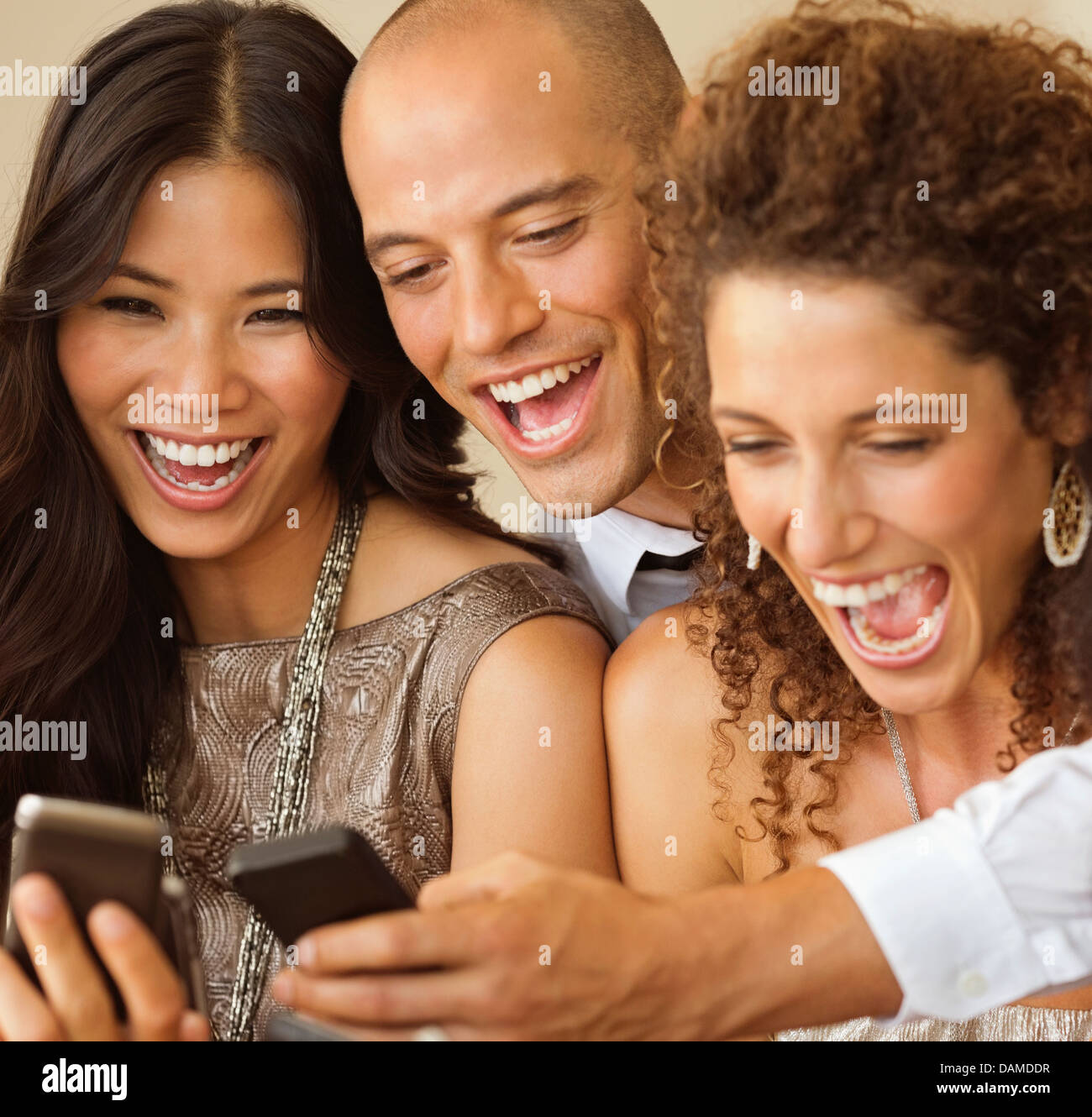 Friends using cell phones together Stock Photo