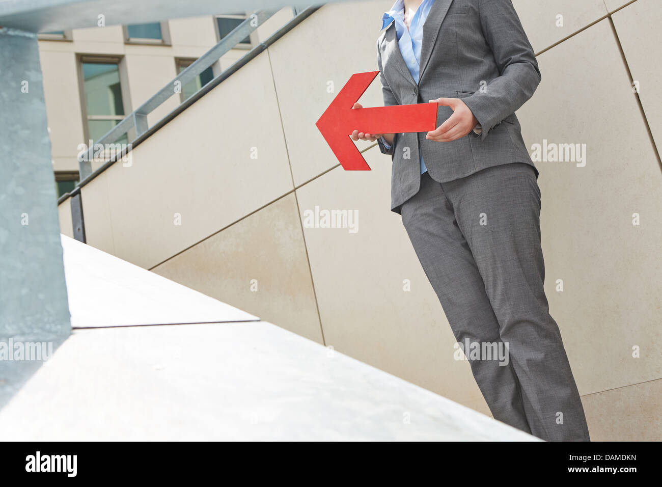Woman holding red big arrow pointing up Stock Photo - Alamy
