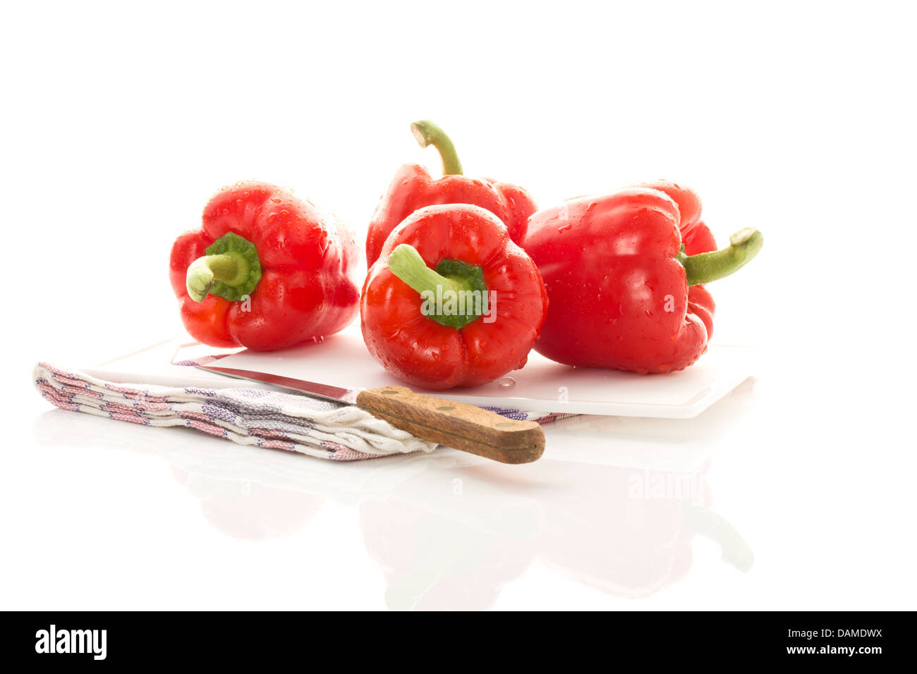 Red bell peppers on chopping board, close up Stock Photo - Alamy