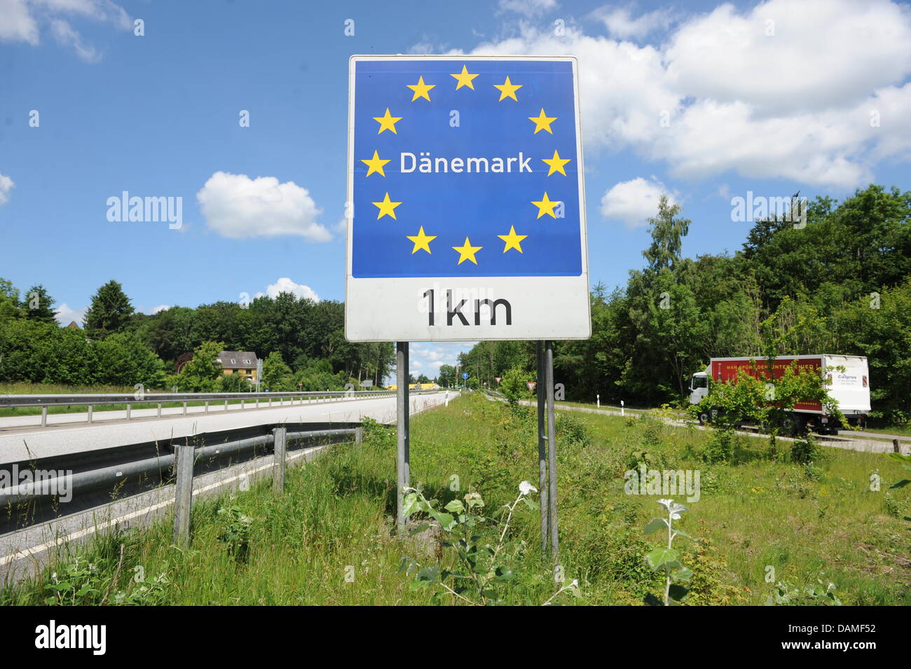 A sign which reads 'Denmark - 1 kilometre' is surrounded by the stars ...
