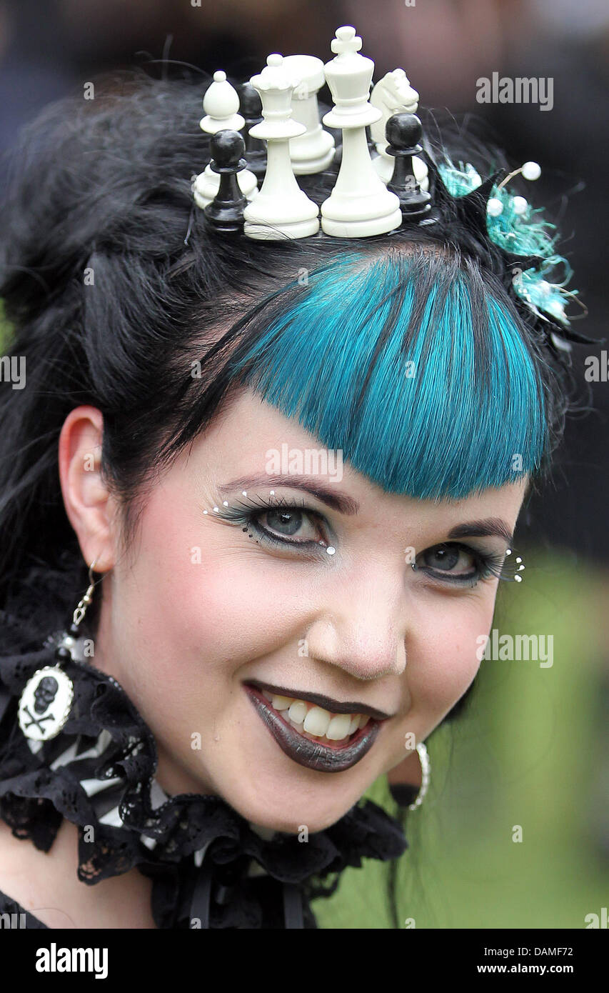 A visitor to the Wave-Gotik-Treffen festival with chess pieces in her hair poses for a photographer in a park in Leipzig, Germany, 10 June 2011. On Pentecost weekend, the organisers of the five-day dark culture festival are expecting 20,000 visitors and on the program are 200 rock and electro bands, midiaeval markets, cemetery tours, a Victorian picnick and even a course in old kni Stock Photo