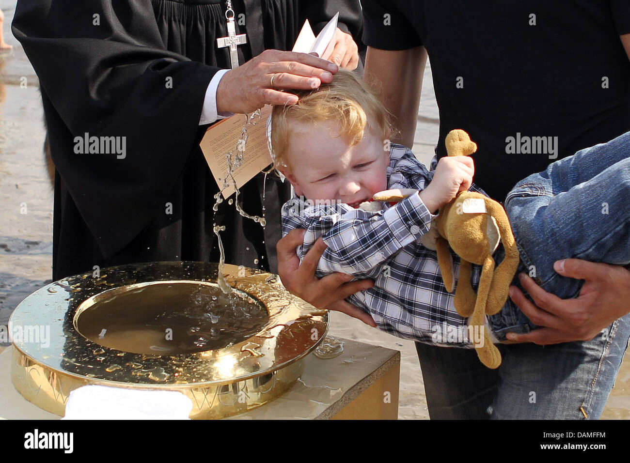 A pastor baptises young boy Fin Kessler during a mass baptism at the