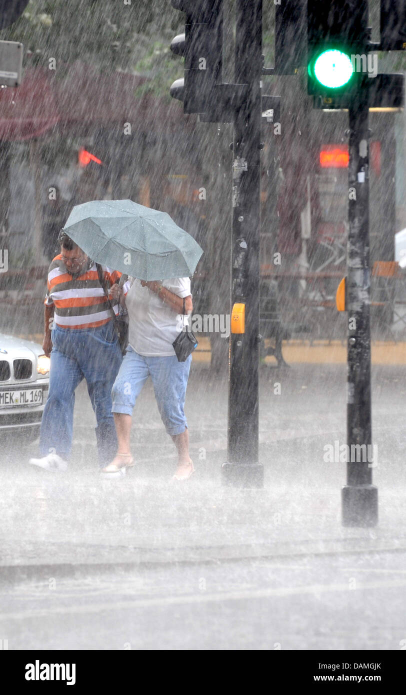 Pedestrians seek shelter from the pouring rain during a thunderstorm in