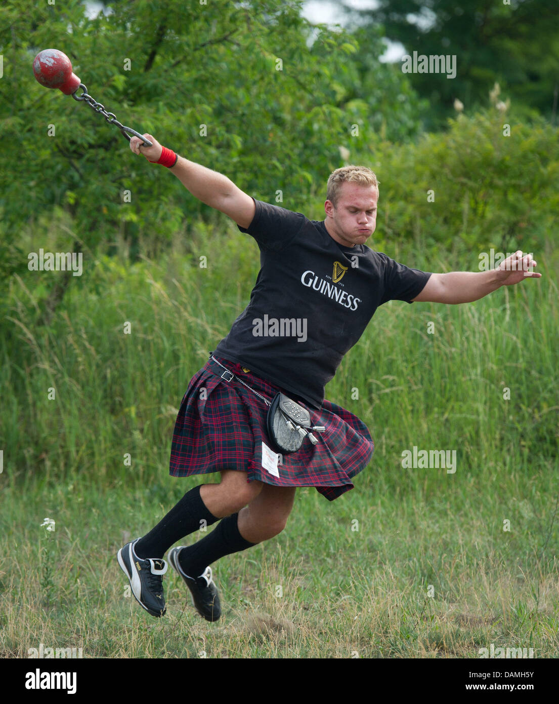 In preperation for the 3rd Highland's festival, kilt wearing Daniel Dorow throws a heavy steel ball on the training ground in Fuerstenwalde, Germany, 15 June 2011. At the so called Highland Games from 18 to 19 June 2011 strong men in a kilt compete in contests like throwing trunks, liftig tractor tires or shot put. More than 100 participanrts are expected. Photo: Patrick Pleul Stock Photo