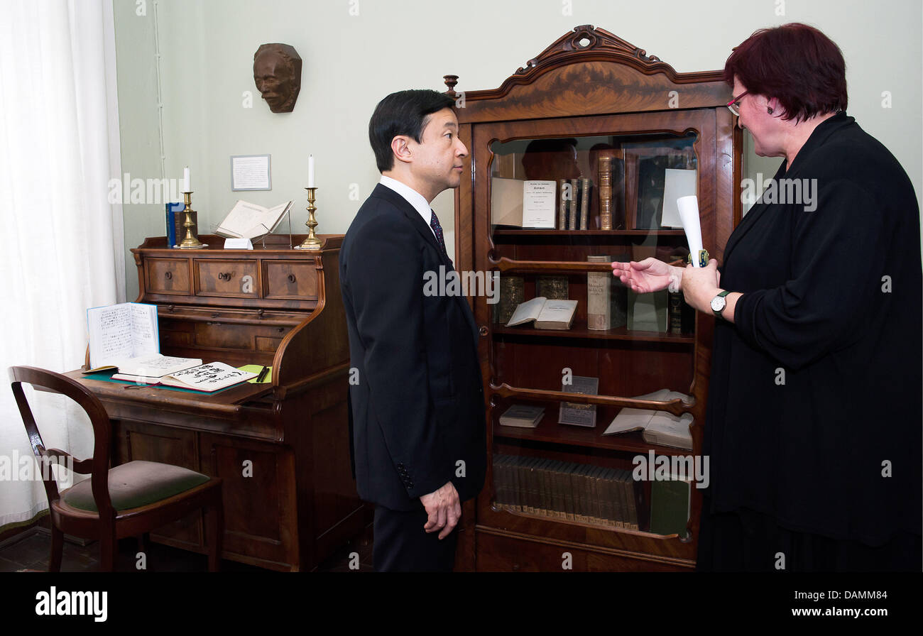 Japanese Crown Prince Naruhito visits the Mori Ogai memorial with the co-director of the site, Beate Wonde, in Berlin, Germany, 22 June 2011. A replica of the death mask of Japanese doctor and poet Mori Ogai (1862-1922) that was made by sculptor Shinkai Chikutaro (1868-1927) hangs on the wall. Naruhito is on a visit to Berlin. Photo: CLEMENS BILAN Stock Photo