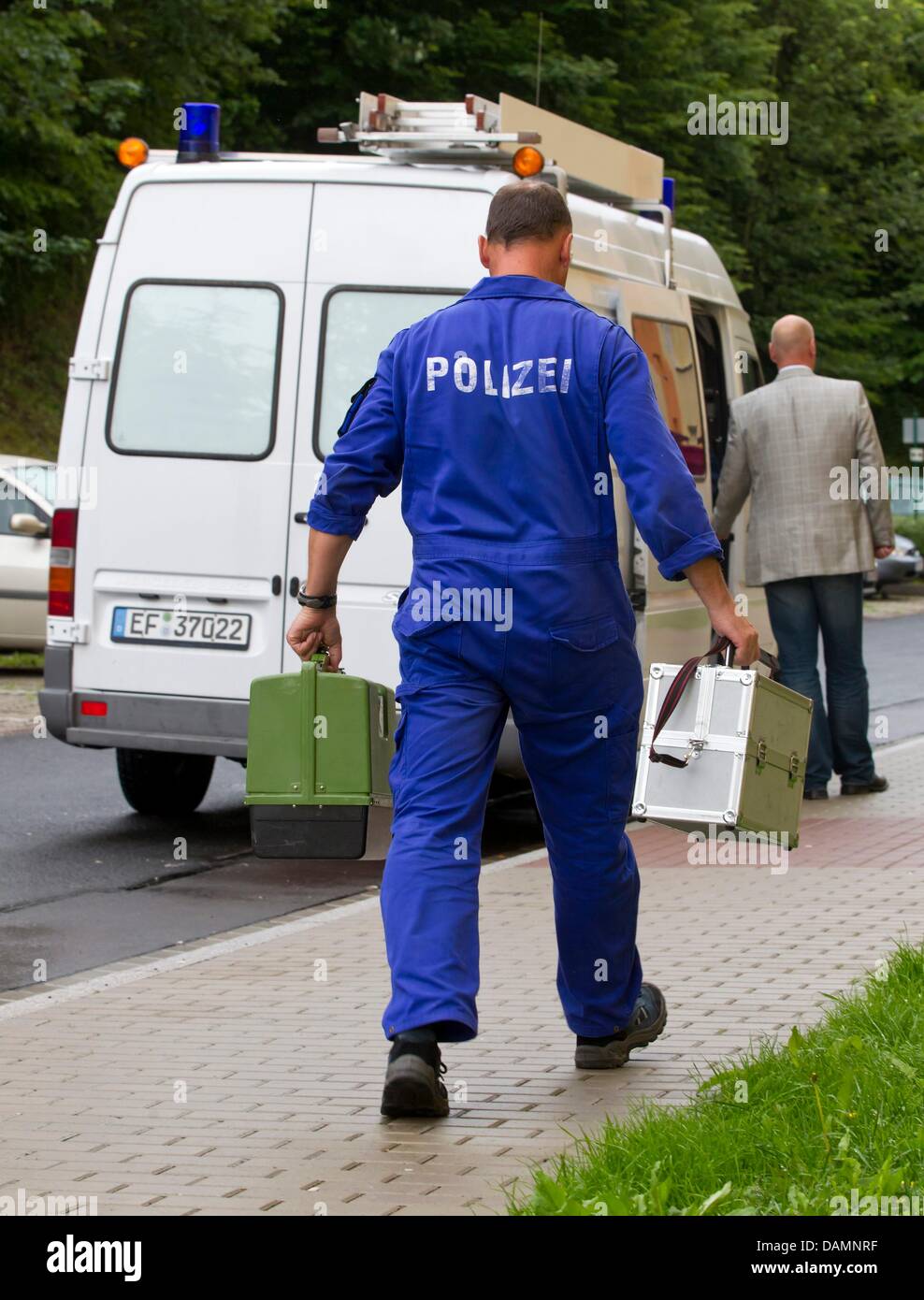 Two policemen of the criminal investigation leave the home of murdered seven-year-old Mary-Jane in Zella-Mehlis, Germany, 26 June 2011. Mary-Jane has been killed by an unknown perpetrator. Just one day after her disappearance her dead body has been found inside a creek 1.5 kilometers off of her mother's apartment. Photo: Michael Reichel Stock Photo