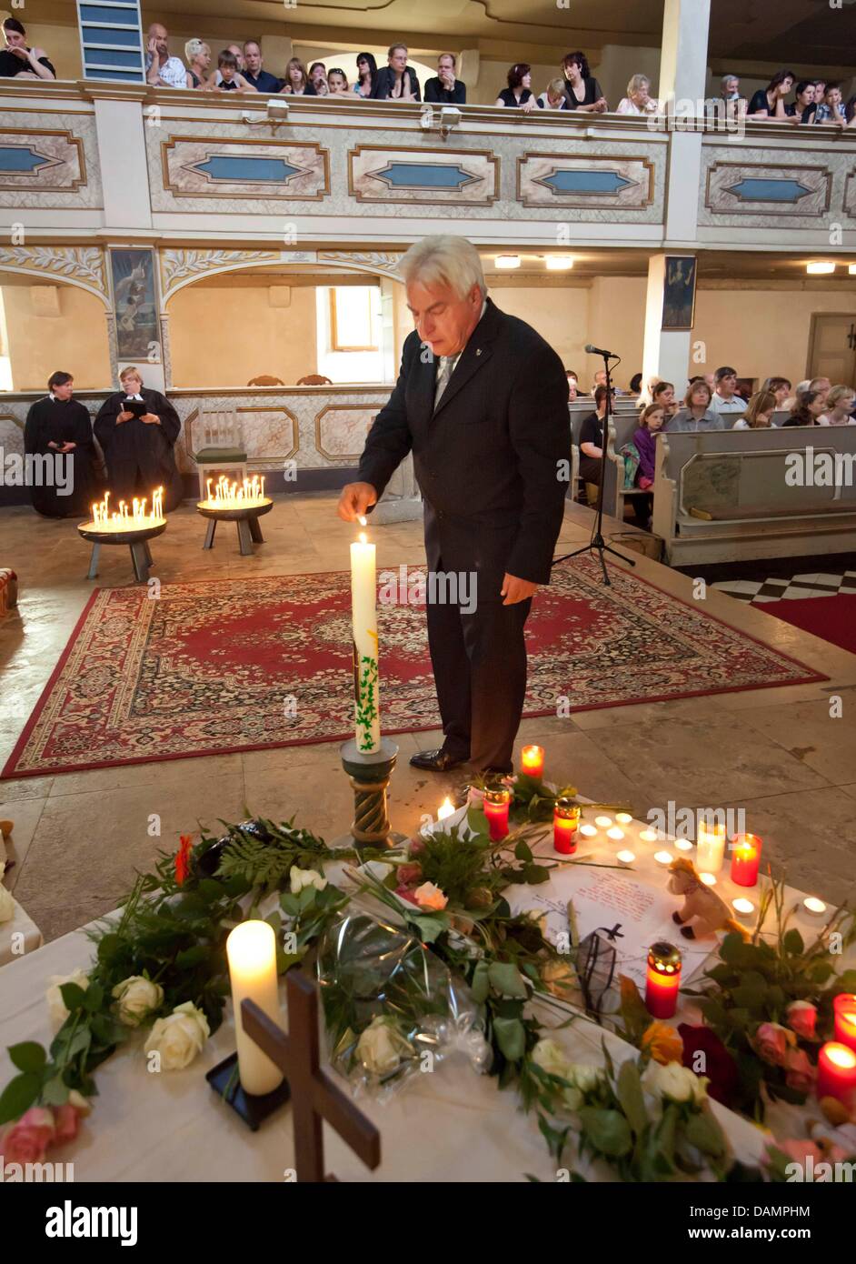 Mayor of Zella-Mehlis Karl-Uwe Panse lights a candle at the alter of the Magdalene Church at the beginning of a memorial service for killed, seven year old Mary-Jane in Zella-Mehlis, Germany, 27 June 2011. Only one day after her disappearance, the body of Mary-Jane was discovered in a stream barely 1.5 kilometers from her mother's home. Photo: Michael Reichel Stock Photo