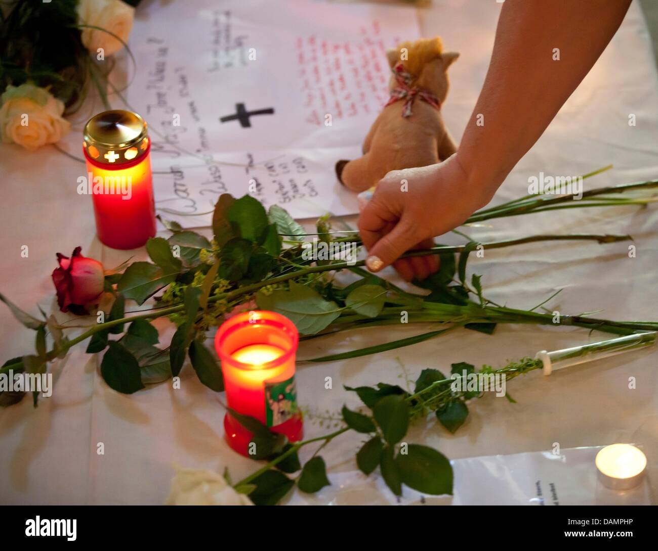 A child lays a flower at the alter of the Magdalene Church at the beginning of a memorial service for killed, seven year old Mary-Jane in Zella-Mehlis, Germany, 27 June 2011. Only one day after her disappearance, the body of Mary-Jane was discovered in a stream barely 1.5 kilometers from her mother's home. Photo: Michael Reichel Stock Photo