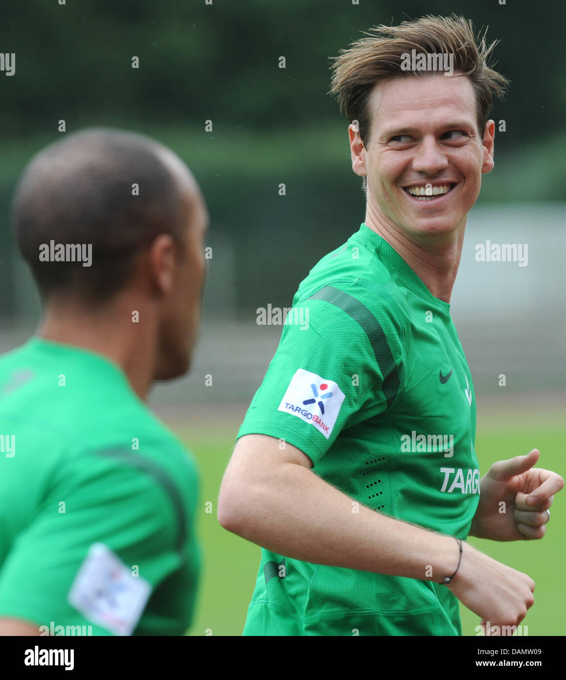 Bremen's player Tim Borowski (R) turns around and smiles at his teammate during a training session of Bundesliga soccer club Werder Bremen for the forthcoming Bundesliga season 2011/2012 in Bremen, Germany, 29 June 2011. Photo: Ingo Wagner Stock Photo