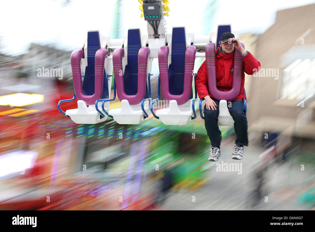 A fairground worker tests his attraction, with the background blurred by speed and movement. Stock Photo