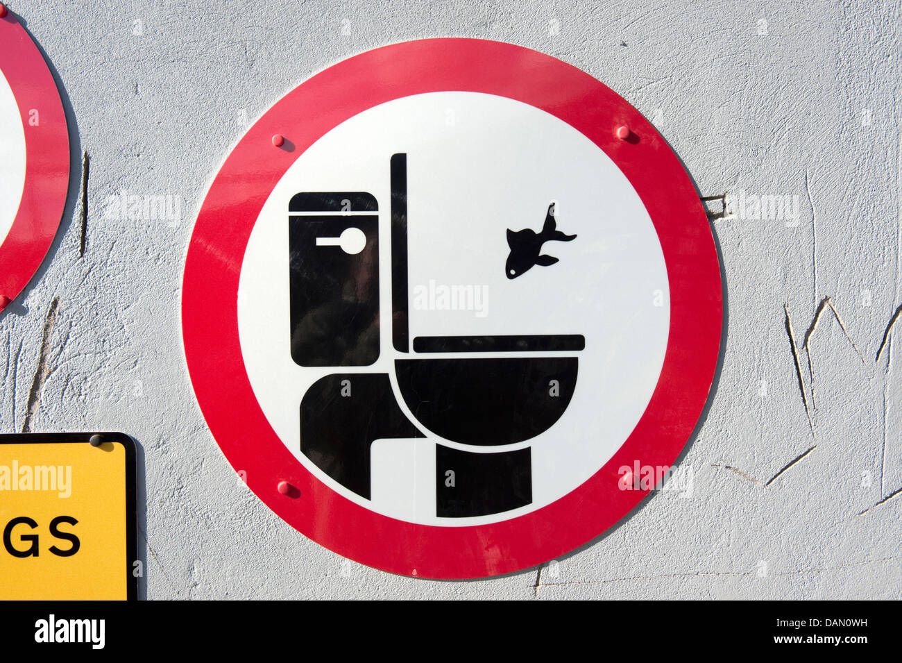 Dead fish flush down toilet sign burial at sea Stock Photo