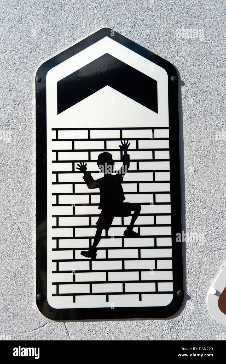 Sign Man Climbing up tall brick wall arrow up Stock Photo - Alamy