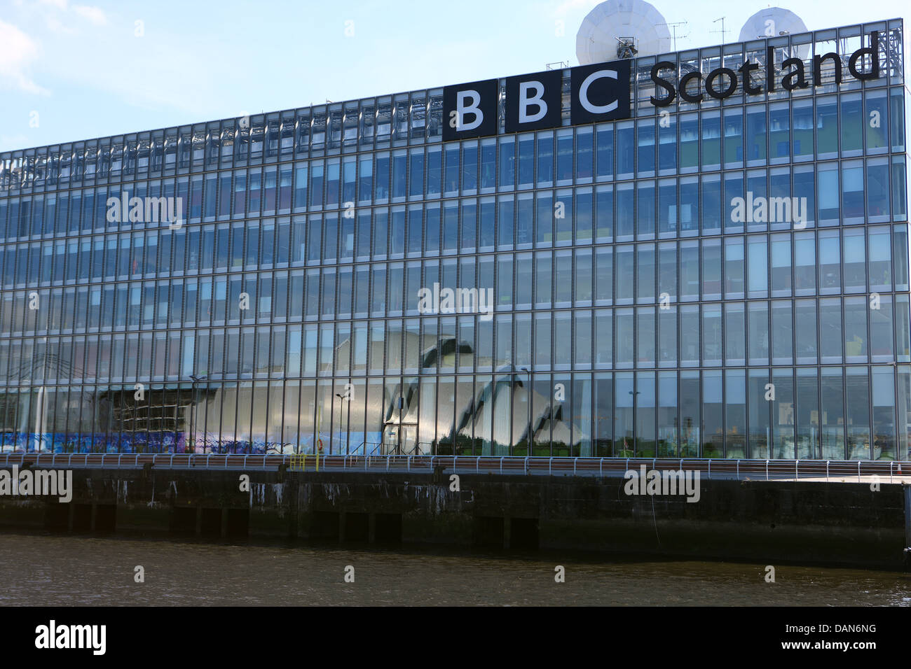 The Armadillo reflected across the River Clyde in Glasgow onto the glass frontage of the BBC Scotland waterfront premises Stock Photo