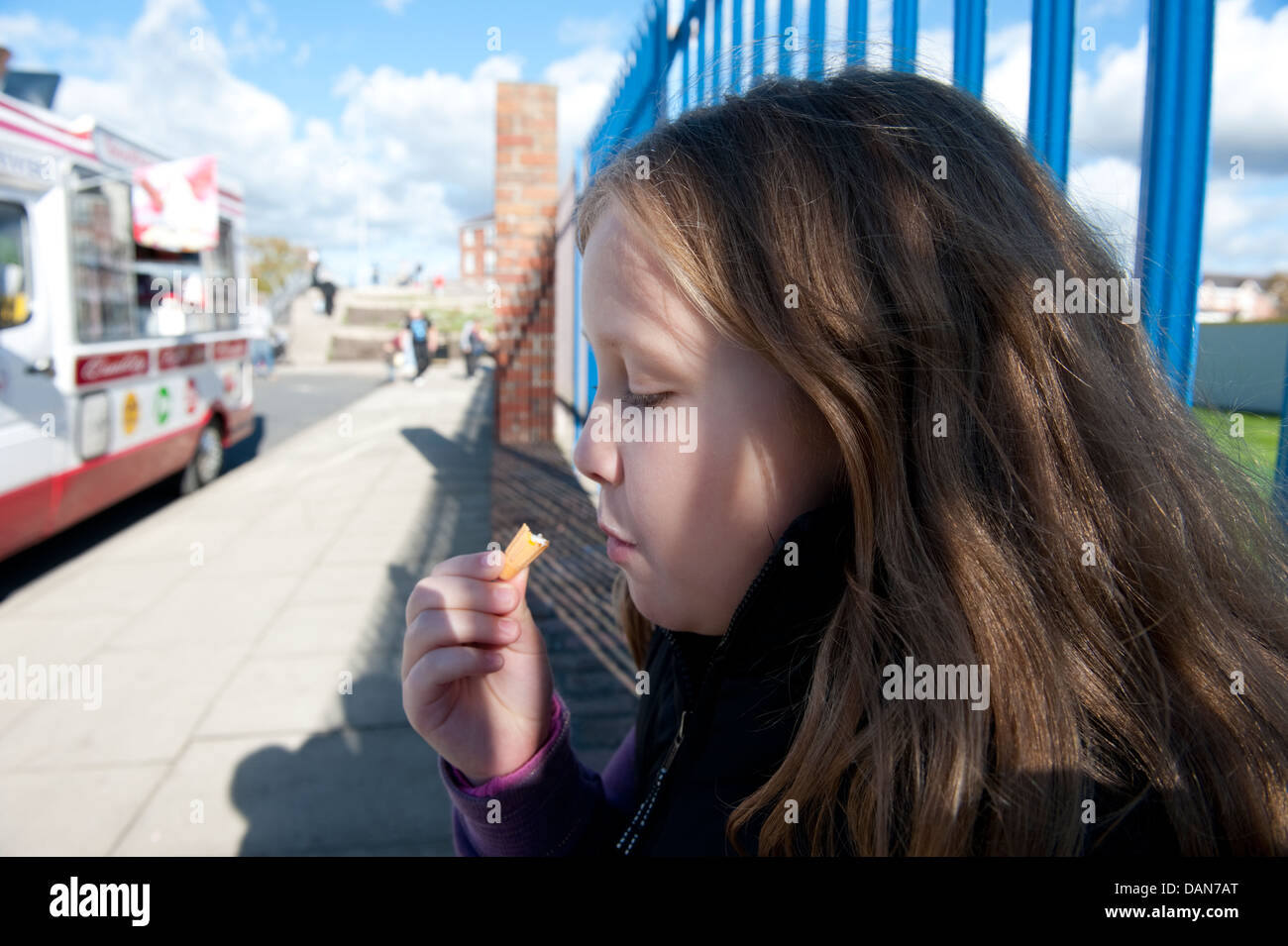 Young girl finishing eating ice cream cone FULLY MODEL RELEASED Stock Photo