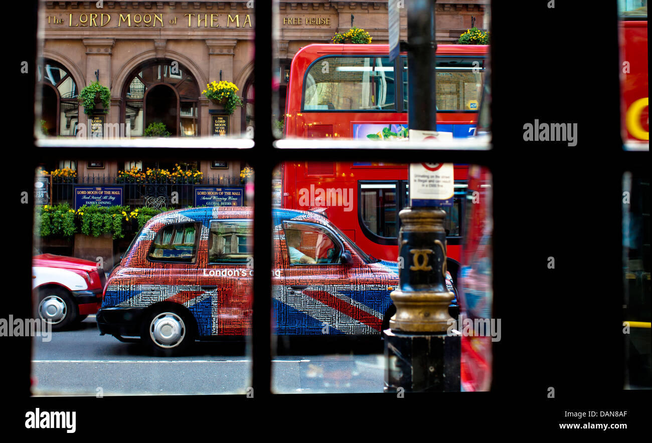 London street view of taxi and red bus from inside of Pub. Stock Photo