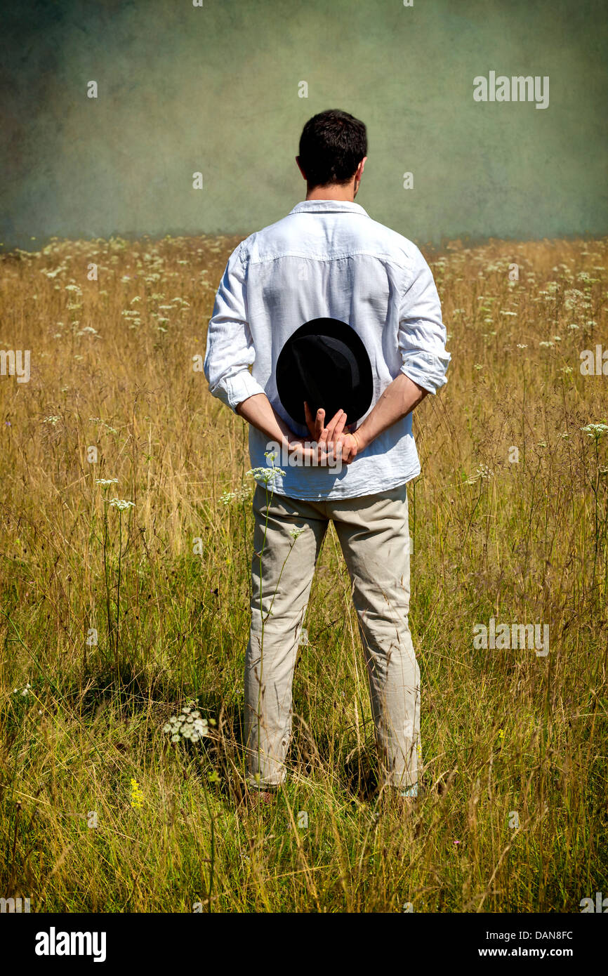 a man with a black hat standing on a field Stock Photo